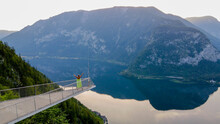 Woman in dress standing on the viewing platform and view of Alps and Hallstatt lake