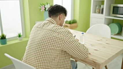 Sticker - Young arab man using paper as a hand fan for hot at home