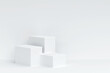© AITTHIPHONG - Three white square pedestal podium and white wall backdrop. White minimal wall scene for product display presentation, 3d rendering
