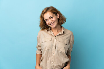 Young Georgian woman isolated on blue background laughing