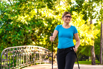 Nordic walking - woman training in city park
