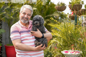 Indian senior man love with dogy puppy. concept about pets and animals.