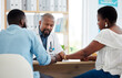 © Nina Lawrenson/peopleimages.com - Doctor, black couple and holding hands in consultation clinic, support and comfort. Healthcare, obstetrician and man and woman talking with medical professional for advice, fertility treatment or ivf