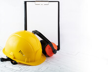 hse, occupational Safety and Health, construction hard hat and protective anti-noise earmuffs with sheet for text in clipboard