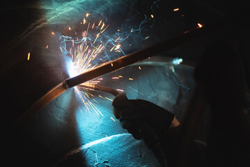 Welder is welding a metal pipes by semi automatic welding.