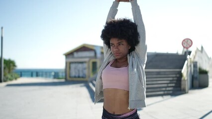 Sticker - African american woman wearing sportswear stretching arms at street