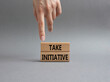 Take initiative symbol. Wooden blocks with words Take initiative. Businessman hand. Beautiful grey background. Business and Take initiative concept. Copy space.