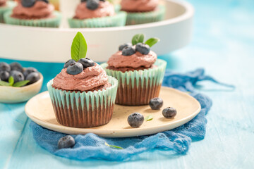 Wall Mural - Delicious and sweet cupcake with chocolate cream and blueberries.