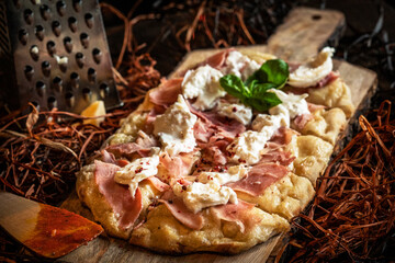 Delicious rustic homemade pinsa style pizza with mozzarella, basil leaf, parmigiano cheese and tomato sauce