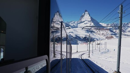 Wall Mural - Riding the iconic cogwheel Gornergrat railway in Zermatt ski resort in the Swiss Alps in Valais, Riding a train in Switzerland on a sunny winter day