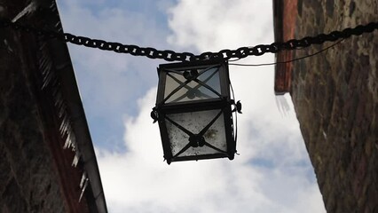 Poster - ancient lantern on a chain in the walls of the castle