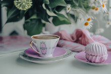 A Gorgeous Fragile White Pink Coffee Cup And Puffy Airy Pink Marshmallow In A Saucer On A White Table. Stylish Pink Dot Scarf, Magazine And Beautiful Sunny Daisies In White Vase On Background.