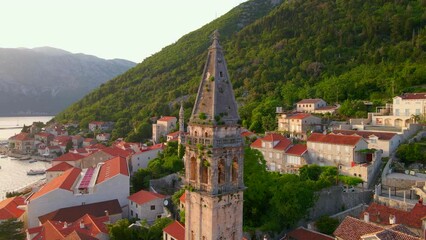 Wall Mural - A stunning aerial view of the charming city of Perast in Montenegro, where the Bell Tower in the church of Saint Nikolas stands out as a focal point. Shot using a drone, the footage captures the city
