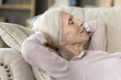 © fizkes - Relaxed sleepy older woman resting on comfortable couch, sleeping, taking nap, enjoying leisure, relaxation at cozy home, breathing fresh cool air, smiling, dreaming