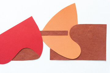 Sticker - cut red, orange, and brown paper shapes with distinct wavy forms and edges on blank paper