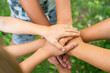 © Надежда Урюпина - children holding hands standing on the green grass, the concept of friendship and a group of young people working in a team