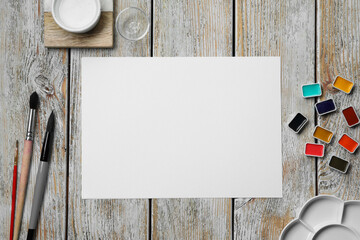 Canvas Print - Flat lay composition with blank paper sheet and watercolor paints on light grey wooden table