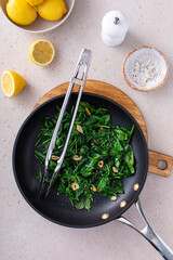 Wall Mural - Sauteed spinach with garlic in a skillet
