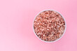 Mockup Pink Himalayan Rock Salt, Halite In White Ceramic Bowl On Pink Background. Top View Horizontal Plane, Copy Space For Text. High quality photo
