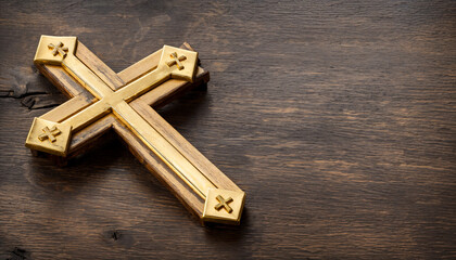 A golden cross lies on a wooden table. Ideal as a banner, wallpaper or header. Space for text. Copy Space, Blank Text.