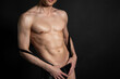 © vladorlov - Adult attractive man with a beautiful body posing in the studio. Black background.