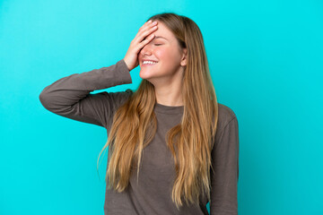 Young blonde woman isolated on blue background smiling a lot