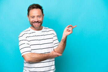 Wall Mural - Middle age caucasian man isolated on blue background pointing finger to the side