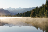 Fototapeta Natura - Capturing the tranquil serenity and reflecting the breathtaking beauty of New Zealand's Lake Matheson, with its calm waters and majestic mountain views.