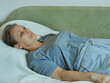 © evafesenuk - Retired woman lying on sofa suffering from depression.