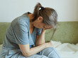 © evafesenuk - Tired senior woman sits on sofa, suffers from depression, hand near head