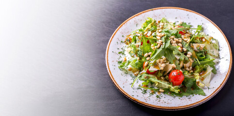 Wall Mural - Arugula salad with pine nuts, cherry tomatoes and cheese on withe plate. Copy space