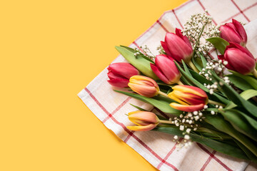 Wall Mural - bouquet of tulips and gypsophila on a yellow background