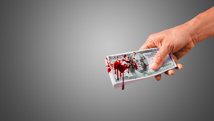 Fototapeta hand giving bloody money. splash blood on $100 banknote. money stained with blood.