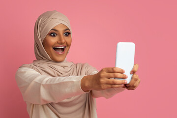 Wall Mural - Great App. Surprised muslim woman in hijab looking at smartphone screen