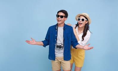 Wall Mural - Happy smiling Asian couple tourist traveler standing hugging and looking copy space isolated on blue background. Vacation time