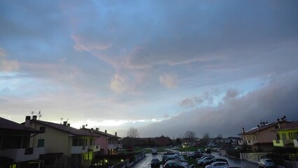 Wall Mural - clouds moving fast in the sky over a small town, time lapse