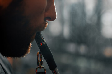 close up young bearded handsome man with beard smoking hookah in lounge bar recreation concept