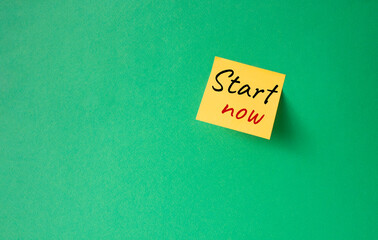 Wall Mural - Start now symbol. Orange steaky note with words Start now. Beautiful green background. Business and Start now concept. Copy space.
