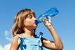 Attractive young beautiful girl drinking water from plastic bottles