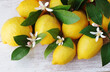 bunch of yellow lemons and flowers on table