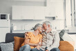 © Daniel - Happy laughing older married couple talking, laughing, standing in home interior together, hugging with love, enjoying close relationships, trust, support, care, feeling joy, tenderness.