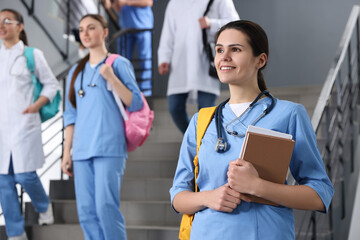 Sticker - Portrait of medical student with books on staircase in college, space for text