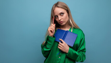 smart blond young woman student meditating with notepad on blue background