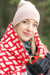 © Татьяна Волкова - Attractive mature blonde woman in hat, wrapped in blanket, drink hot coffee or tea. looking at camera in nature outdoors