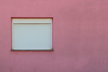 white window with shutters on pink wall