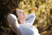 Happy Woman Resting On A Bench Smiling