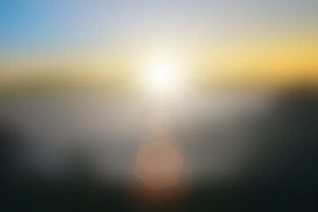 Wall Mural - Natural background blurring warm colors and bright sun light. Sky sunny color orange light patterns plain abstract flare evening clouds blur.