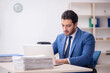 © Elnur - Young male employee and too much work in the office