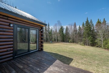 beautiful contemporary rustic log cabin on a rural field in the mountains