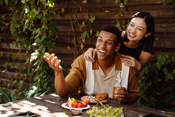 Cheerful couple having fun during dinner at backyard